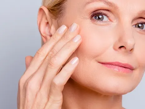 closeup of middle aged woman touching her cheek