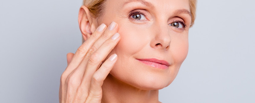 closeup of middle aged woman touching her cheek